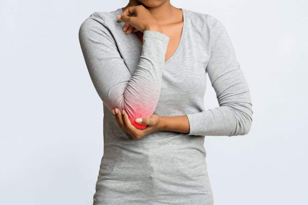 Young woman having acute pain in elbow joint