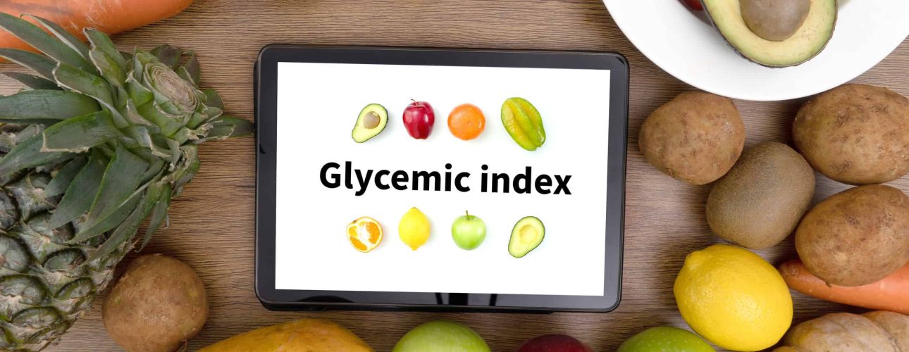 Glycemic index Fitness and weight loss concept, dumbbells, white scale, fruit and tape measure on a wooden table, top view