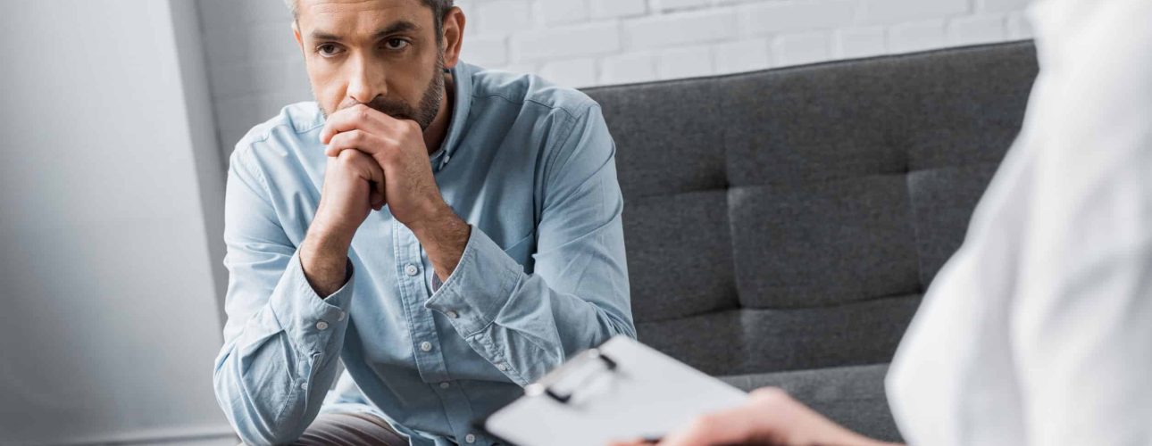 depressed adult man on psychologist therapy session at office