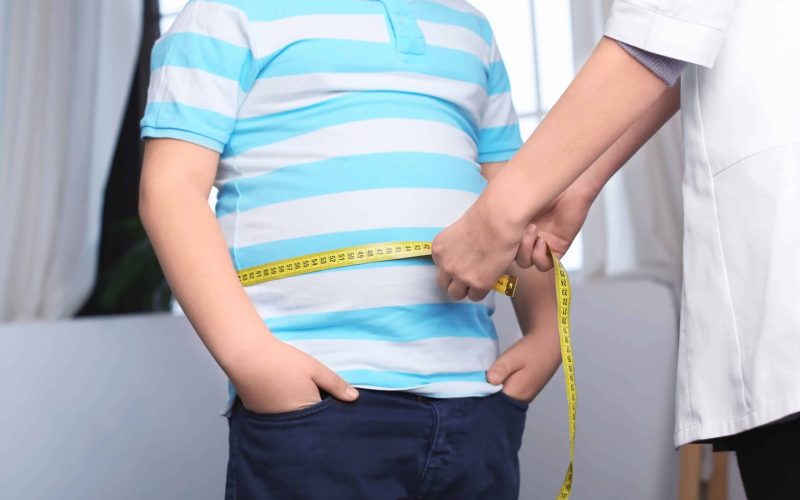 Doctor measuring overweight boy in clinic