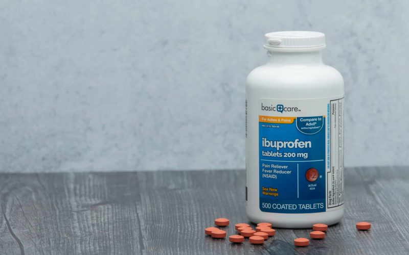 Houston, TX - May 6, 2020: A closeup of an isolated new bottle of generic brand ibuprofen on a wooden table.