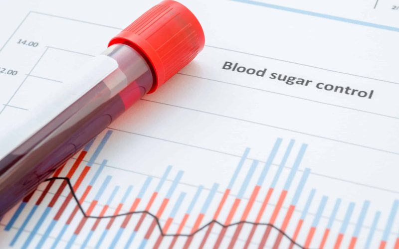 Sample blood for screening diabetic test in blood tube on blood sugar control chart.