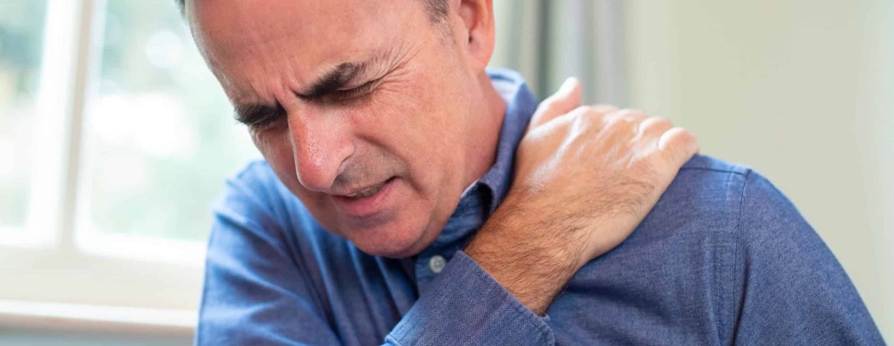 Mature Man Suffering With Trapped Nerve In Shoulder At Home