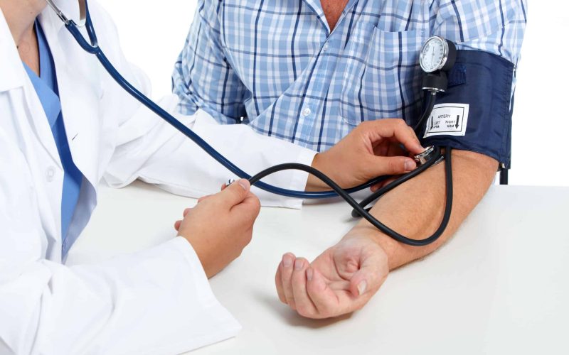 Doctor checking old man patient arterial blood pressure. Health care.