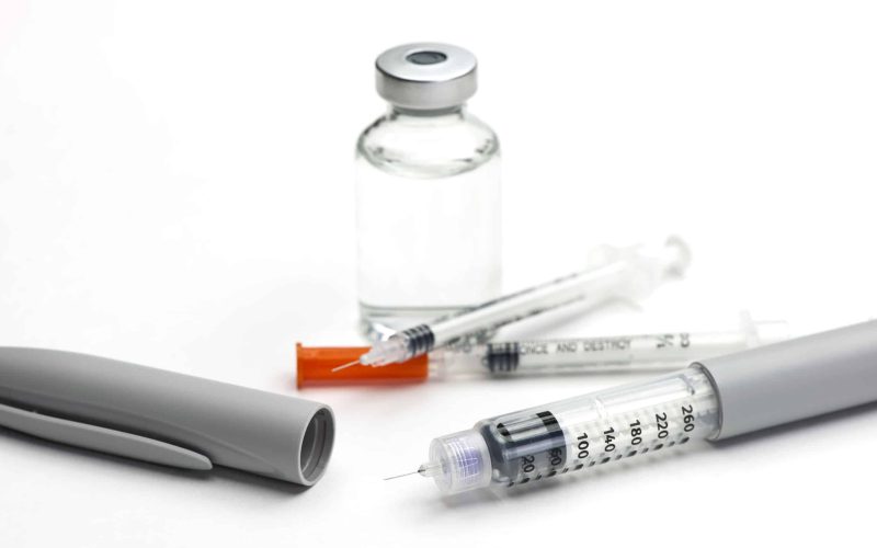 Insulin pen and insulin syringe with glass bottle of insulin.