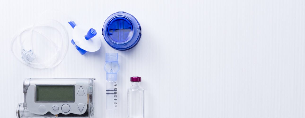 top view of an insulin pump set background consisting of: an insulin pump, insertion system of the infusion set, a reservoir of a insulin pump, insulin vial and a infusion set on a white background