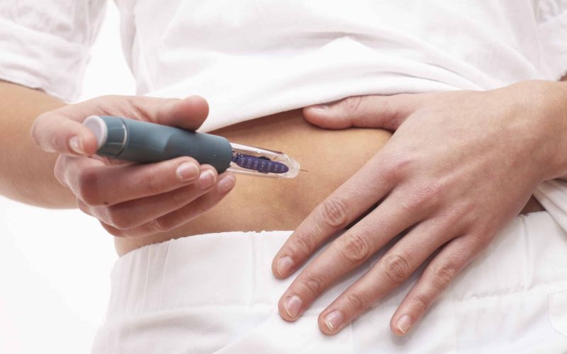 Young woman is injecting Insulin with a Insulin Pen