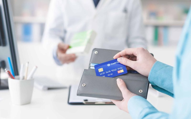 Woman buying medical products in the pharmacy, she is taking the credit card from the wallet