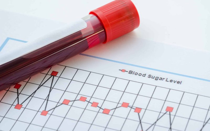 Sample blood for screening diabetic test in blood tube on blood sugar control chart.