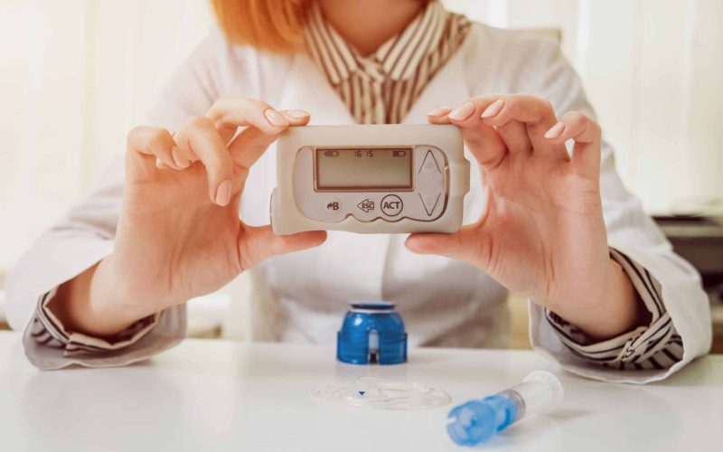 Doctor holding the insulin pump at his hands. Diabetes concept.