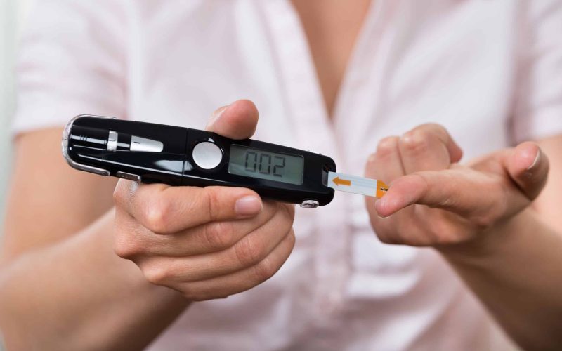 Close-up Of Woman Hands Testing High Blood Sugar With Glucometer